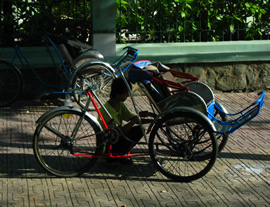 Traditional Vietnamese cyclos parked on a Ho Chi Minh City sidewalk